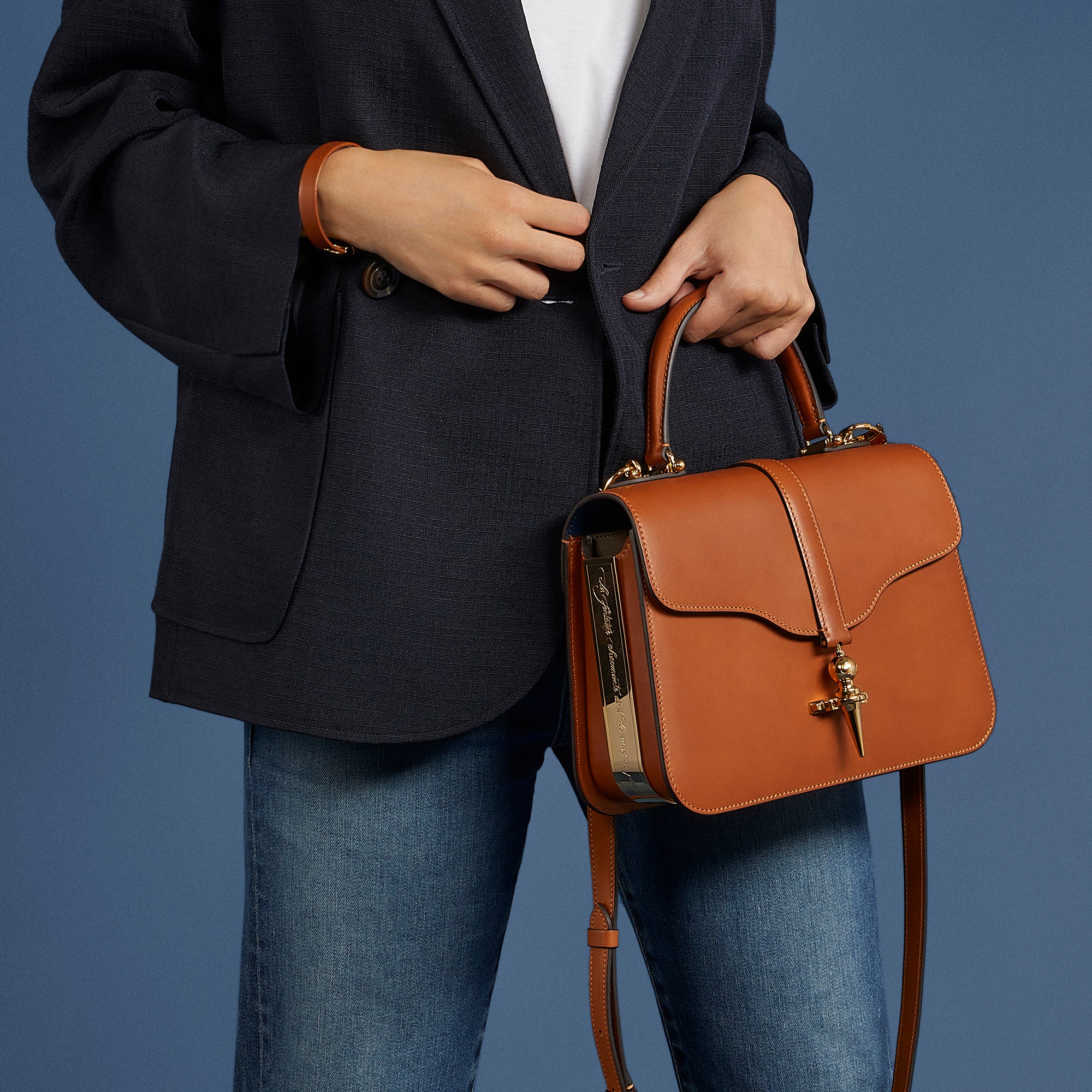 Diane - Joseph Duclos - Avec sa coupe élégante, son cuir naturel et son fermoir iconique, le sac Diane rend hommage à la déesse chasseresse. Tout comme elle, il célèbre la féminité à la fois puissante et naturelle. Porté au bras ou sur l’épaule grâce à sa bandoulière, il donne à la femme qui le possède une allure pleine de noblesse.  Dimensions: L:26cm X H: 16,5cm X P: 8cm  Fabriqué en France 