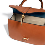 Avec sa coupe élégante, son cuir naturel et son fermoir iconique, le sac Diane de chez Joseph Duclos, rend hommage à la déesse chasseresse. Tout comme elle, il célèbre la féminité à la fois puissante et naturelle. Porté au bras ou sur l’épaule grâce à sa bandoulière, il donne à la femme qui le possède une allure pleine de noblesse.